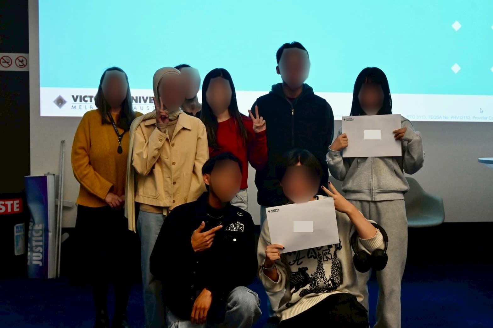 修了証を手にクラスメートと集合写真