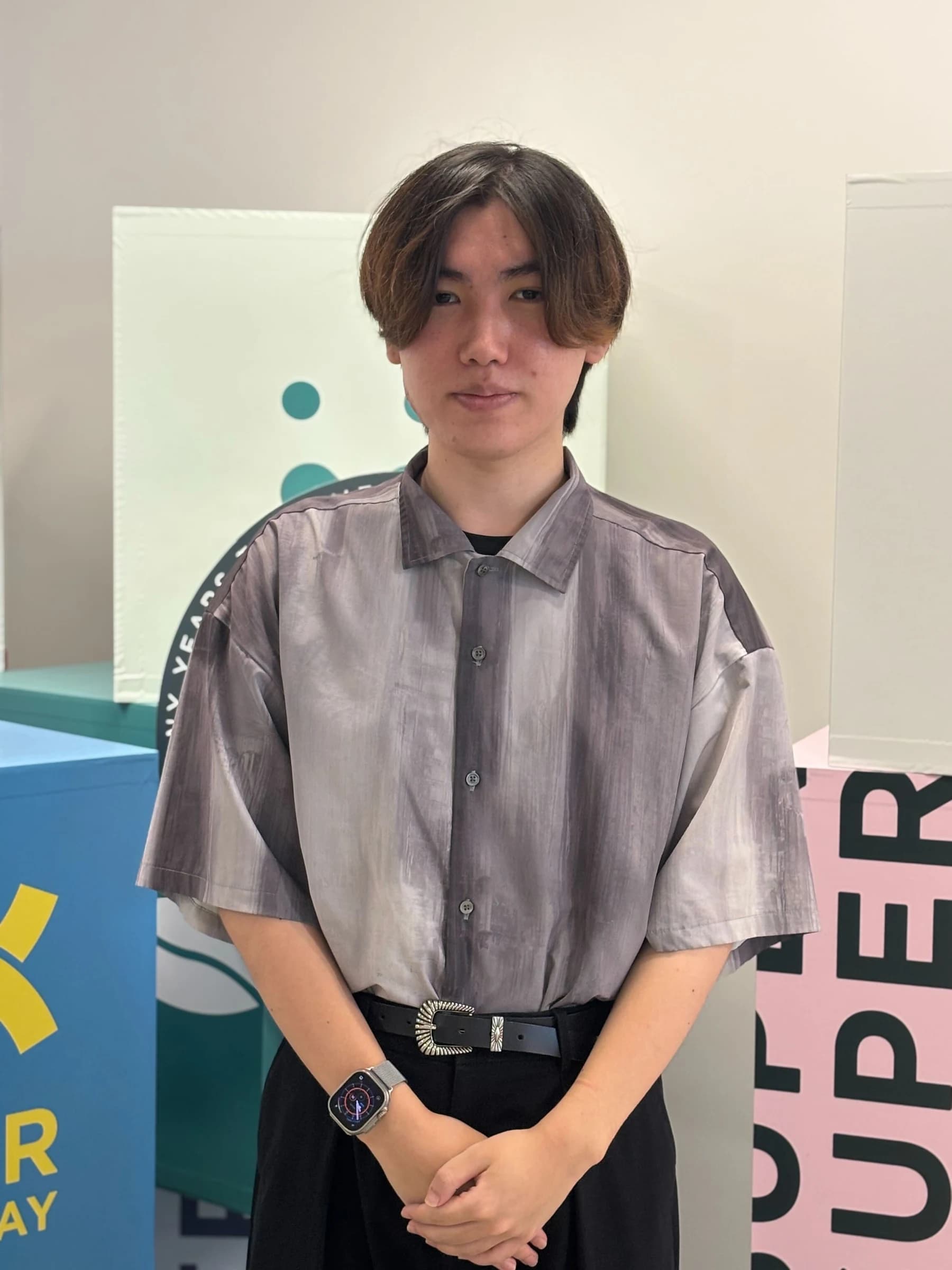 プレイドのロゴがあるオフィスで撮影した白田連大の全身写真